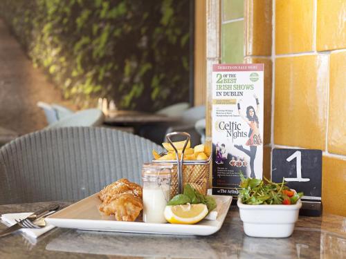 a table with a plate of food on a table at Arlington Hotel O'Connell Bridge in Dublin