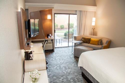ロッキーマウントにあるCourtyard by Marriott Rocky Mountのベッドとソファ付きのホテルルーム