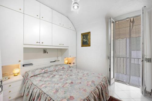 - une chambre blanche avec un lit et une fenêtre dans l'établissement Via Corradi, à Sanremo