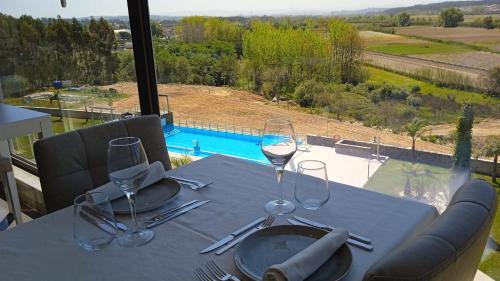 a dining table with wine glasses and a view of a pool at Lisotel - Hotel & Spa in Leiria