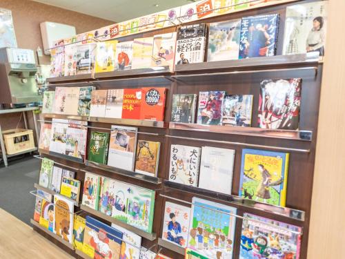 a book shelf filled with books in a store at Omotenashi Hostel Miyajima in Hatsukaichi