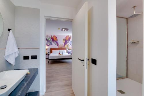 a bathroom with a sink and a shower and a bedroom at RoccaRegina Hotel in Sciacca