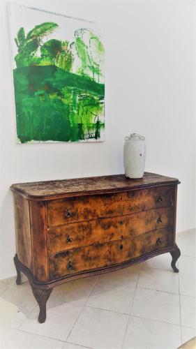 a wooden dresser in a room with a painting at Residenza Bertolini in Fosdinovo