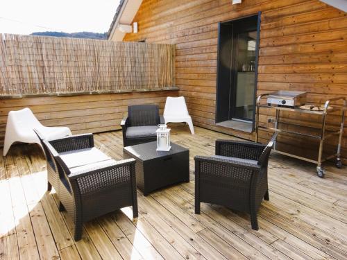 a patio with chairs and tables on a wooden deck at STUDIO TERRASSE in Le Thillot