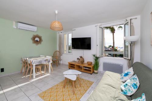 a living room with a couch and a table at Emplacement idéal au cœur de Sanary sur le port vue mer in Sanary-sur-Mer