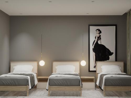 a room with two beds and a painting of a woman at Split Rooftop Suites in Durrës