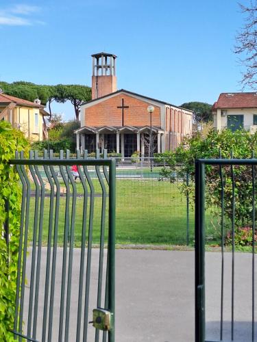a fence in front of a building with a tower at La casina di Marco in Marina di Pietrasanta