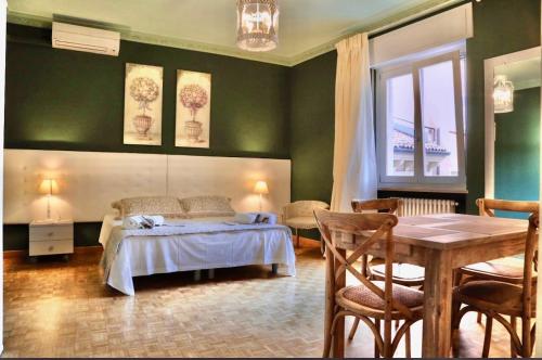 a bedroom with a bed and a table and a window at La Casetta di Lina Rooms and Apartments in Verona