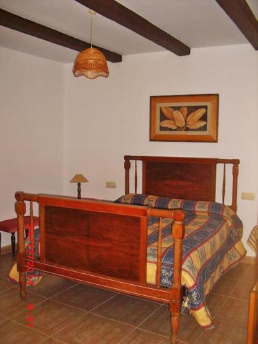 1 dormitorio con cama de madera en una habitación en Casa del Abuelo 1, en Yeste
