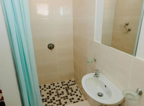 a bathroom with a sink and a shower at Golden Candle Guest House in Roodepoort