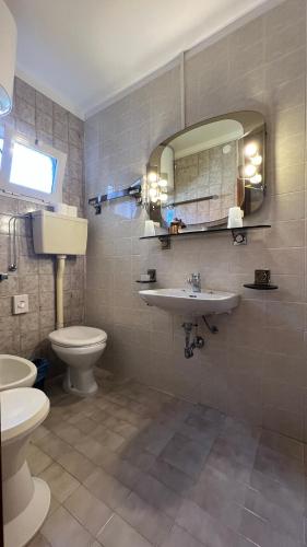 y baño con lavabo, aseo y espejo. en Residence Madrid Stanza en Lido di Jesolo