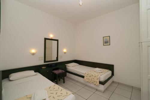 Pokój z 2 łóżkami i lustrem w obiekcie Villa Aristea w mieście Kalo Chorio