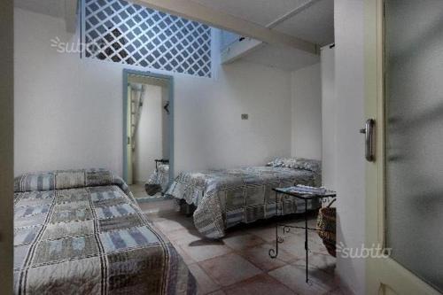a bedroom with two beds and a table in it at Dimore Dell'Isola Rossa in Isola Rossa