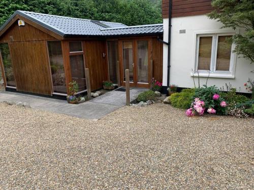 a house with a gravel yard next to a building at Self catering apartment at Beechwalk House. in Enniskerry