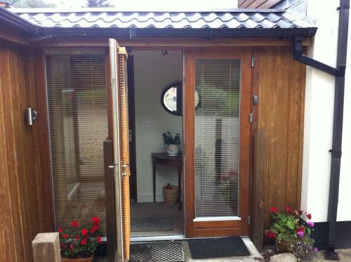 uma entrada para uma casa com uma porta de madeira em Self catering apartment at Beechwalk House. em Enniskerry