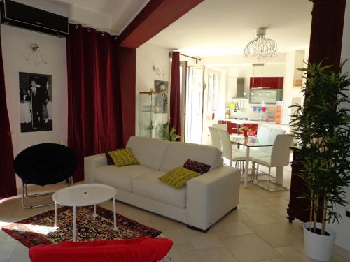 a living room with a white couch and a kitchen at Appartamento Ogliastra in Lanusei
