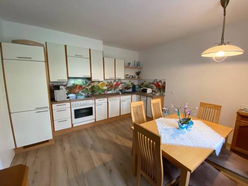 a kitchen with a dining table and a kitchen with white cabinets at Ruhiges Ferienhaus nahe Kurort Bad Gleichenberg. 