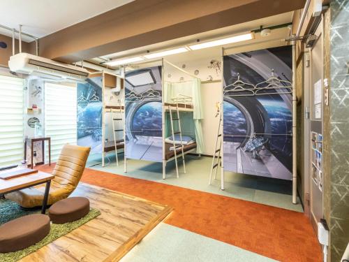 a room with bunk beds and a table and chairs at Omotenashi Hostel Miyajima in Hatsukaichi