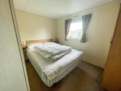 a bed in a bedroom with a window at Lovely 8 Berth Caravan At Southview Park Nearby Skegness Ref 33009v in Skegness