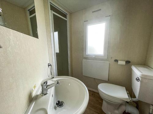 a bathroom with a sink and a toilet and a window at Lovely 8 Berth Caravan At Southview Park Nearby Skegness Ref 33009v in Skegness