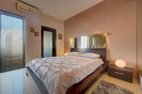 a bedroom with a large bed and a mirror at Steps from the Sea, Side Sea-View, 3BR Sleep 6 in St. Paul's Bay