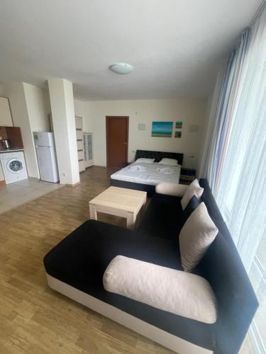 ein Wohnzimmer mit einem Sofa und einem Bett in der Unterkunft Lozenetz Beach Apartments in Lozenets