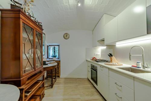 a large kitchen with white cabinets and a sink at Masia Mimosa in Darnius