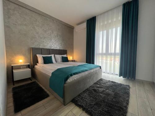 une chambre avec un grand lit et une grande fenêtre dans l'établissement Gala Residence Baile Felix, à Cordău