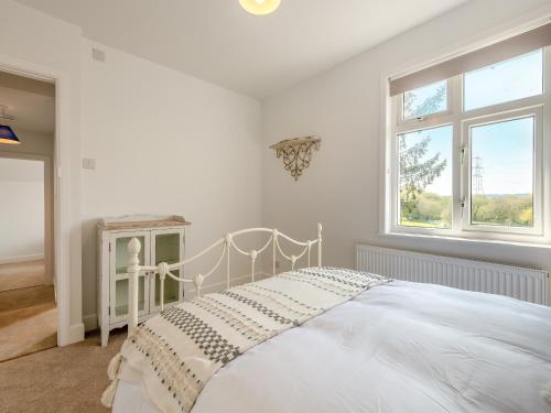 a white bedroom with a bed and a window at Avondale in Woodgreen