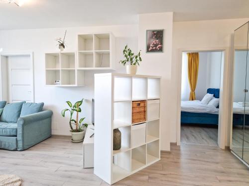 AZUR Apartment في تيميشوارا: غرفة معيشة مع رفوف بيضاء وأريكة زرقاء