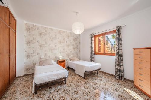 a bedroom with two beds and a window at C'an Crespí in Consell