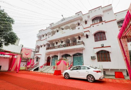 a white car parked in front of a building at J C Guest House in Hasanganj