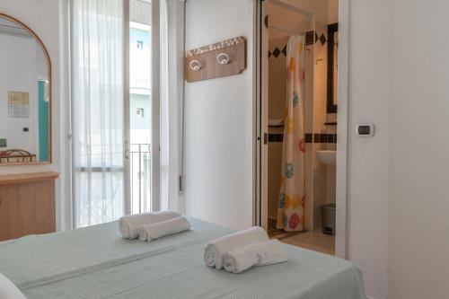 una camera da letto con due asciugamani seduti su un letto di Hotel Greta B&B a Rimini