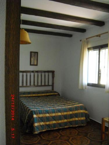 1 dormitorio con 1 cama con manta a cuadros en Casa del Abuelo 2 en Yeste