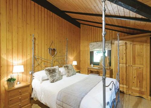 a bedroom with a bed in a room with wooden walls at Springwood Lodges in Harrogate