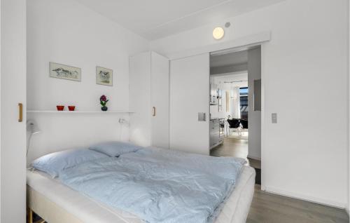 een witte slaapkamer met een bed en een hal bij Fan Bad, Lejl, 57 in Fanø