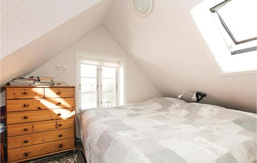 a bedroom with a bed and a dresser and a window at Two-Bedroom Holiday Home In Ronne in Rønne