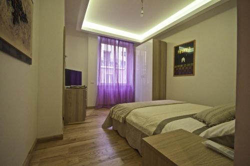 een slaapkamer met 2 bedden en een raam met paarse gordijnen bij Piramide House in Rome