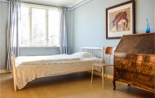 a bedroom with a bed and a dresser and a window at 2 Bedroom Nice Apartment In Holmsjö in Holmsjö