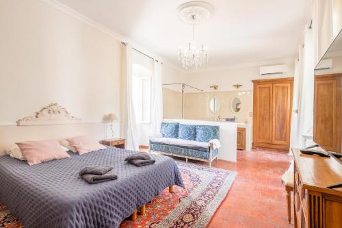 a bedroom with a bed and a blue couch at Casa Pietra - Piscine privative et toit terrasse in Montegrosso