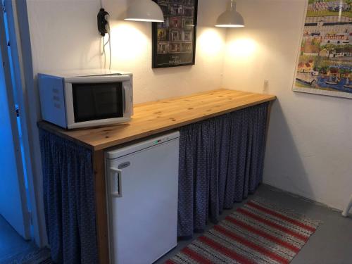a kitchen with a counter with a microwave and a refrigerator at Svartarp Gård in Åseda