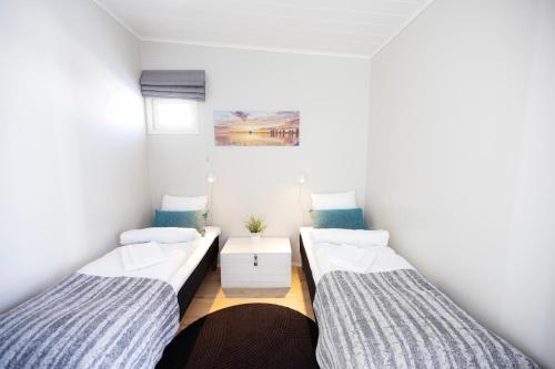 a room with two beds and a table at Nallikari Seaside Villas in Oulu