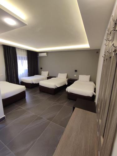 a room with four beds in a room at Black Iris Hotel in Madaba