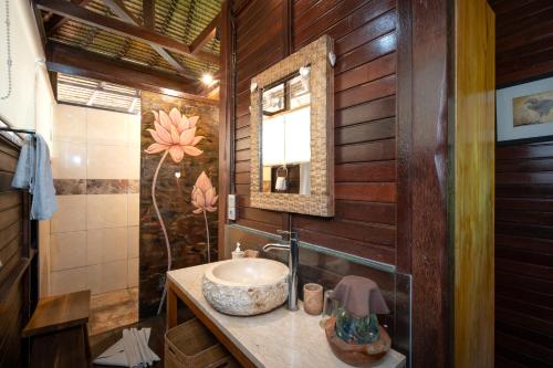 a bathroom with a sink and a mirror at Kupu Kupu Private Villa in Ubud