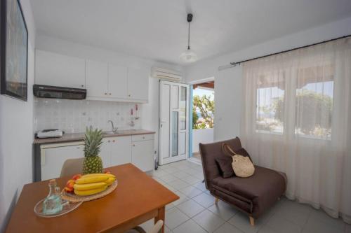 a kitchen with a table with bananas and a chair at Creta Sun Mochlos in Mochlos