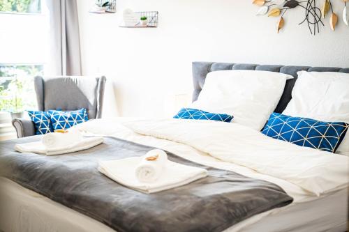uma cama com lençóis brancos e toalhas em APARTMENTO Magdeburg - Zentral - 2 Zimmer - WiFi - Netflix em Magdeburg
