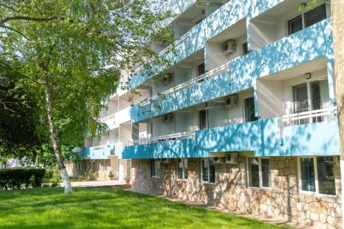 um edifício de apartamentos com uma fachada azul e branca em Mera Holiday Resort em Venus
