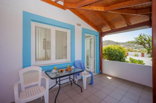 a room with a table and chairs on a balcony at Creta Sun Mochlos in Mochlos
