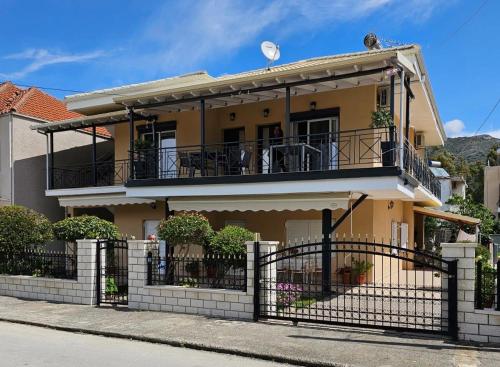 Casa amarilla con balcón en una calle en Ioulia`s Apartments en Plataria
