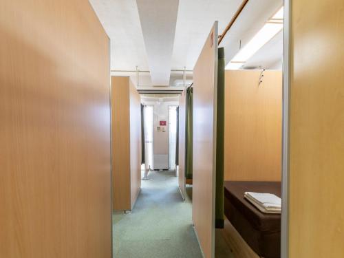 a hallway of a hospital with a bed and a door at Omotenashi Hostel Miyajima in Hatsukaichi